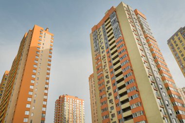 Modern bir şehrin mimarisinin bir parçası olarak pencereleri ve balkonları olan çok katlı bir binanın ön cephesi.