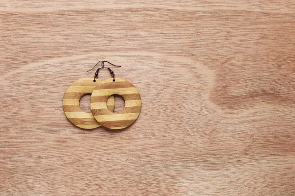 Wooden earrings on wooden background