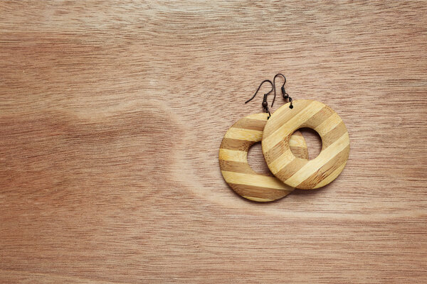 Fashion earrings on wooden surface