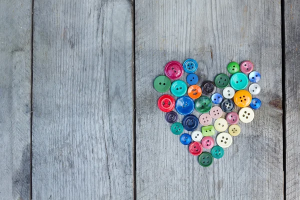 Ahşap arka plan üzerinde bir kalp şeklinde Vintage düğmeleri — Stok fotoğraf
