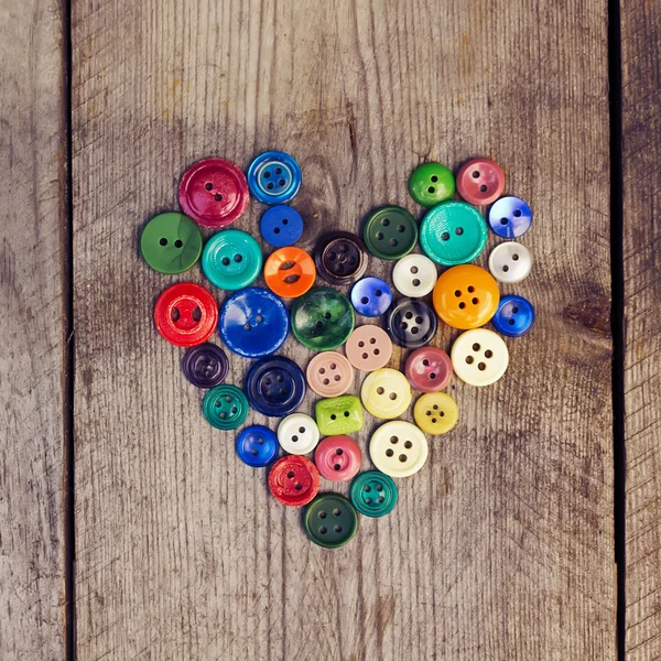 Vintage buttons in the shape of a heart on a wooden  background — Stock Photo, Image