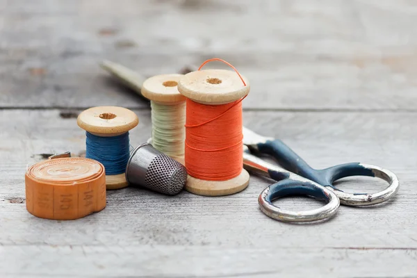 Fundo com ferramentas de costura e linha colorida — Fotografia de Stock