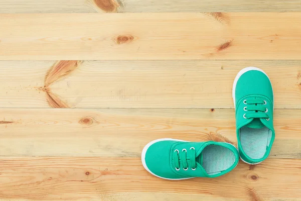 Sapatos verdes em um soalho de madeira . — Fotografia de Stock