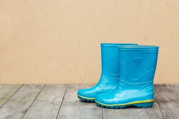 Bottes en caoutchouc bleu sur un plancher en bois — Photo