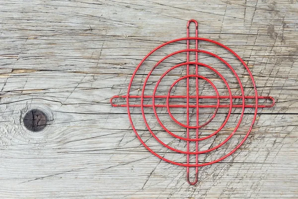 Cruz metálica roja sobre una vieja superficie de madera —  Fotos de Stock