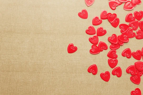 Red hearts confetti on beige background — Stock Photo, Image