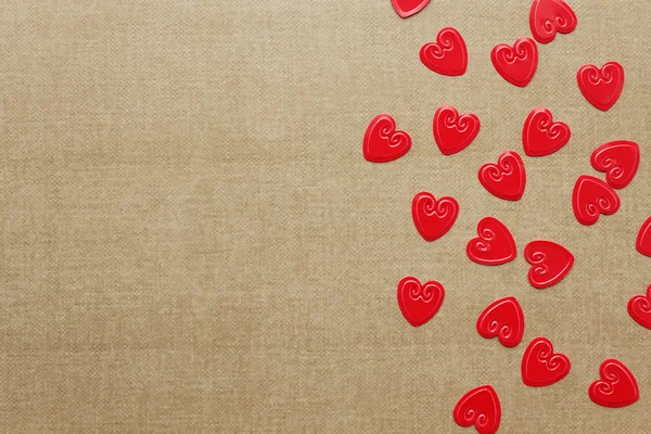 Bej renkli arka plan üzerinde kırmızı kalpler konfeti — Stok fotoğraf