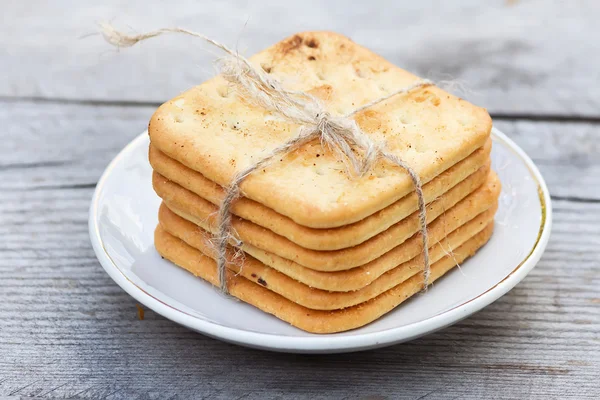 Biscoitos salgados em uma chapa na mesa branca — Fotografia de Stock