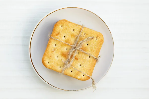 Biscoitos salgados em uma chapa na mesa branca — Fotografia de Stock