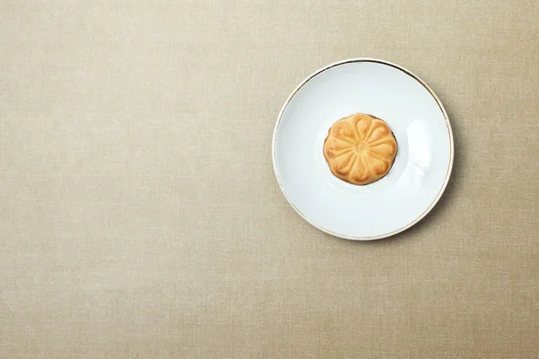Ένα μπισκότο σε ένα πιάτο σε μπεζ φόντο — Φωτογραφία Αρχείου