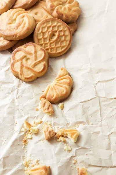 Biscoitos e migalhas sobre papel amassado — Fotografia de Stock