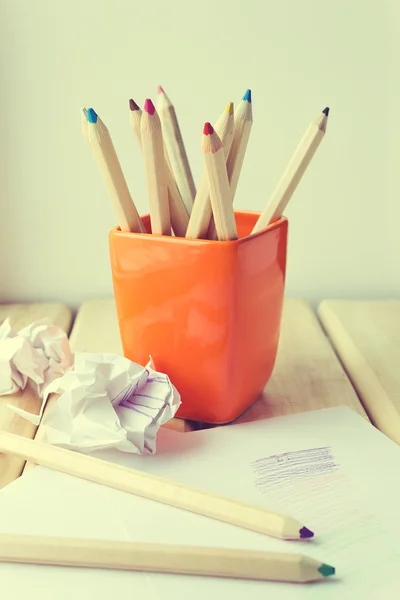 Kopp med färgglada pennor på träbord — Stockfoto