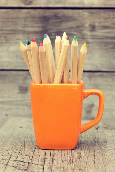 Lápices de color en una taza naranja — Foto de Stock