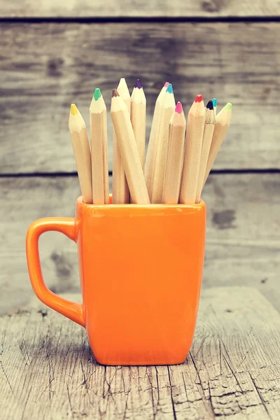 Crayons de couleur dans une tasse orange — Photo