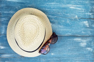 Şapka, güneş gözlüğü mavi zemin üzerine