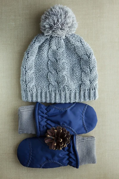 Šedý klobouk, tmavě modré rukavice a šiška — Stock fotografie