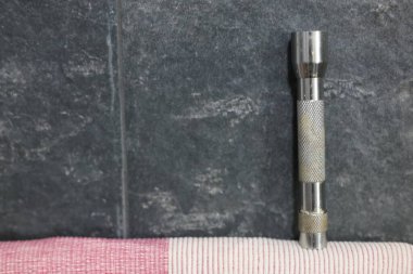 Küçük metalik ve kirli bir el feneri.