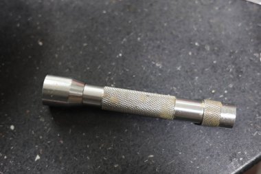 Küçük metalik ve kirli bir el feneri.