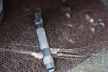 Küçük metalik ve kirli bir el feneri.