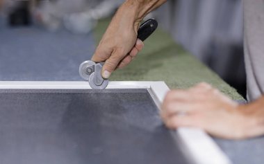 Pencere perdesi yapan bir adam. Sivrisinek ağı takmak için tekerlek aletli bir adamın elini görebilirsiniz..