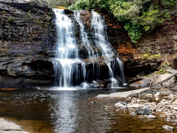 Oakland, Maryland 'deki Swallow Falls Eyalet Parkı' ndaki Muddy Falls şelalesi sonbaharda kayaların kenarından süzülüp dökülen yapraklar aşağıdaki suya düşüyor..