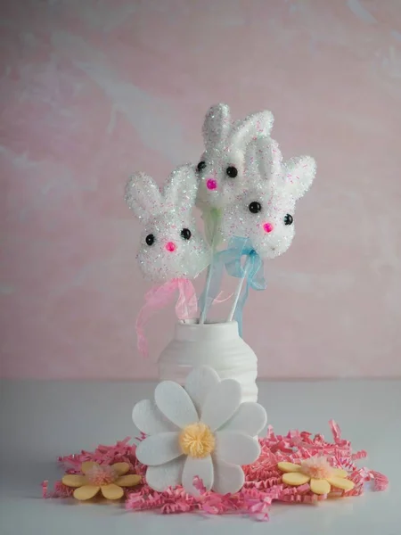 Пасхальные Кролики Белой Вазе Окружении Розовой Бумаги Куски Войлочные Ромашки — стоковое фото