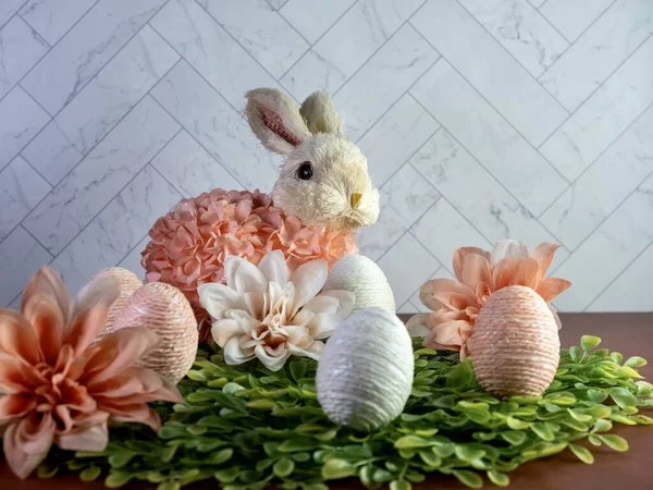 Wielkanocny Królik Siedzący Łożu Zielonych Liści Kwiatami Brzoskwini Dahlia Stringami — Zdjęcie stockowe