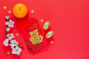 Kırmızı zarf paketleri veya ang bao (kelime zenginlik anlamına gelir) altın külçeleri, portakal ve Çin çiçekleri Çin için kırmızı arka planda yeni yıl çiçekleri.