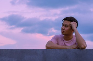 Asyalı sefil bunalımlı adam gökyüzü geçmişiyle yalnız kalıyor. Depresyon ve akıl sağlığı kavramı.