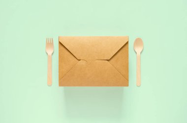 Dünya Çevre Günü konsepti için tek kullanımlık kağıt yemek kutusu, çatal ve kaşık yeşil arka plan.. 