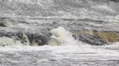 İnce bir su tabakası eğimli yüzey boyunca akar ve kayalardan düşen yapay bir şelale oluşturur.