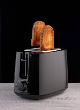 Lezzetli kızarmış ekmek dilimleri tost makinesinden uçar.