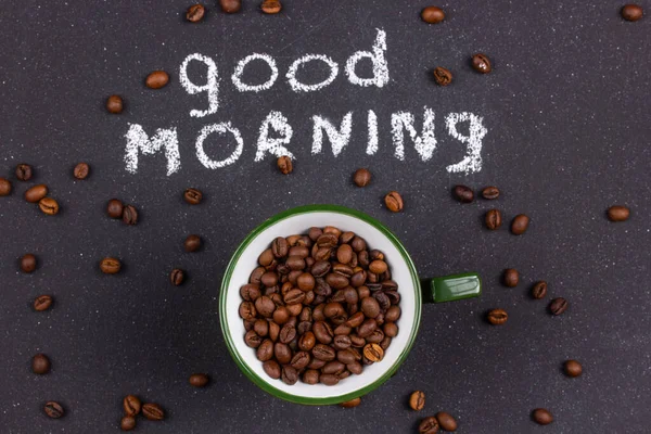 Bir kupa kahve çekirdeği ve karanlık masanın üzerinde... - Günaydın.