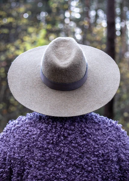 Femme dans un grand chapeau gris se tient avec son dos — Photo