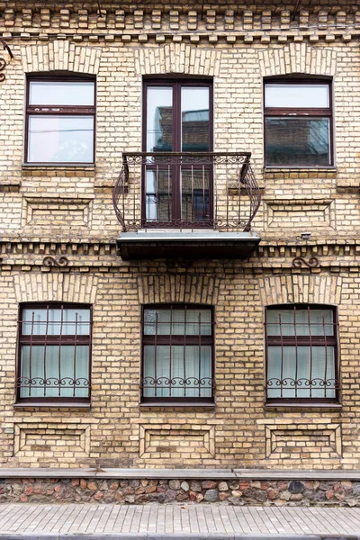 Antiguo edificio de ladrillo de dos plantas con un balcón — Foto de Stock