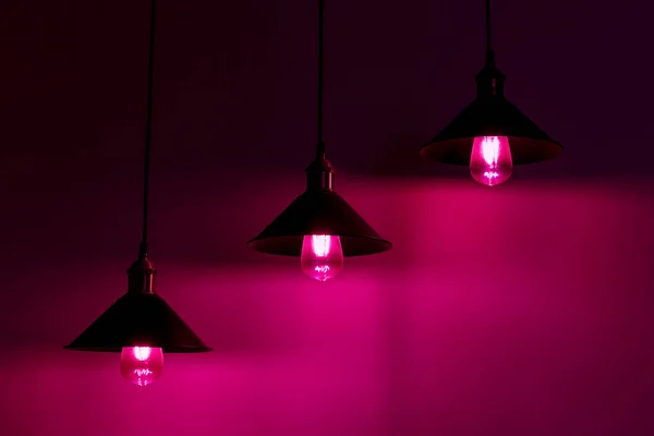 Three lamps with vintage incandescent bulbs in pink light — Stock Photo, Image