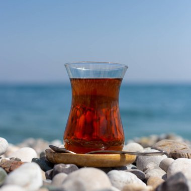 Armudu. Kumsalda bir bardak çay.