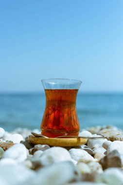 Armudu. Kumsalda bir bardak çay.