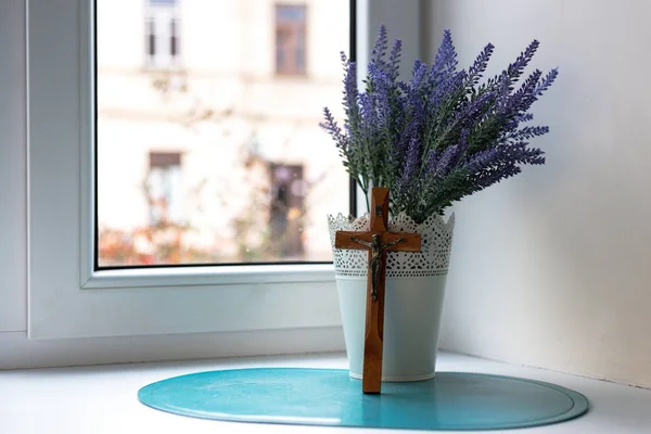 Houten kruis en lavendel boeket bij het raam — Stockfoto