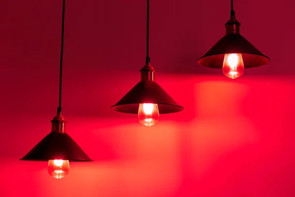 Três lâmpadas com lâmpadas incandescentes vintage. Luz vermelha. — Fotografia de Stock