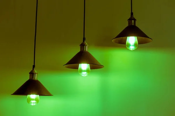 Três lâmpadas com lâmpadas incandescentes vintage em luz verde — Fotografia de Stock