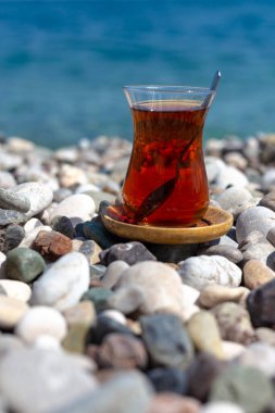 Armudu. Kumsalda bir bardak çay.