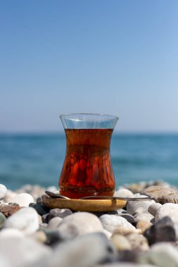 Armudu. Kumsalda bir bardak çay.
