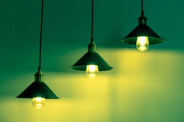 Três lâmpadas com lâmpadas incandescentes vintage em luz verde — Fotografia de Stock