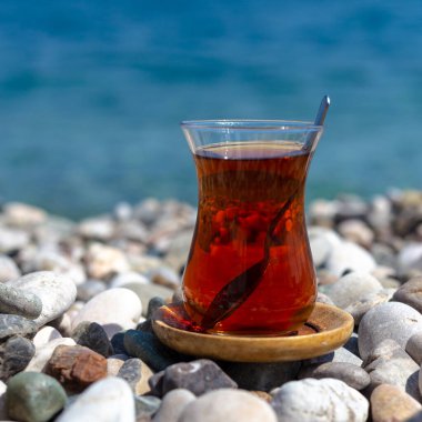 Armudu. Kumsalda bir bardak çay.