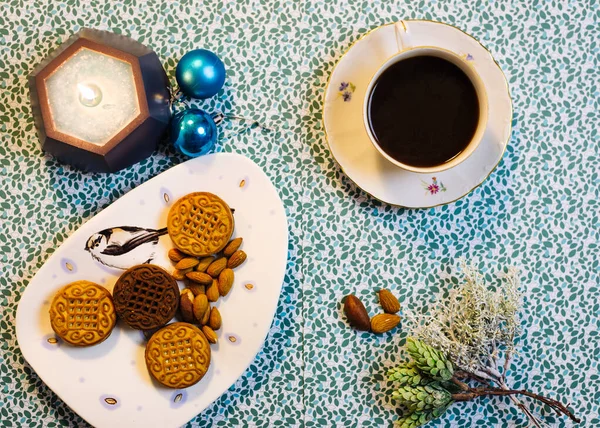 Taza de café, velas, galletas y decoraciones navideñas sobre un fondo azul —  Fotos de Stock