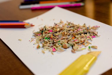  Renkli kalemler, beyaz bir arka plan ve kırtasiye bıçağı.