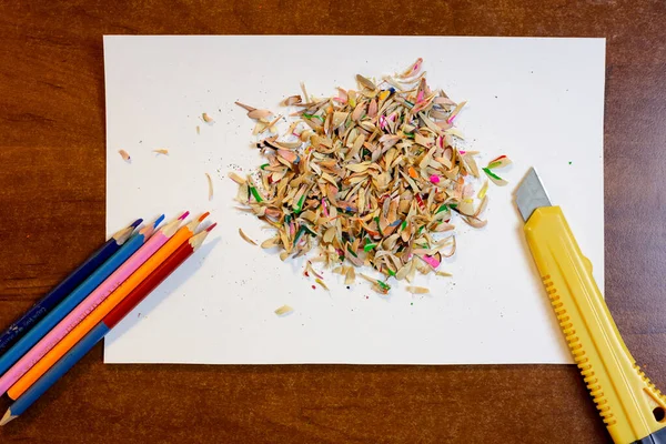 Colored pencils, shavings on a white background and a stationery knife — Stock Photo, Image