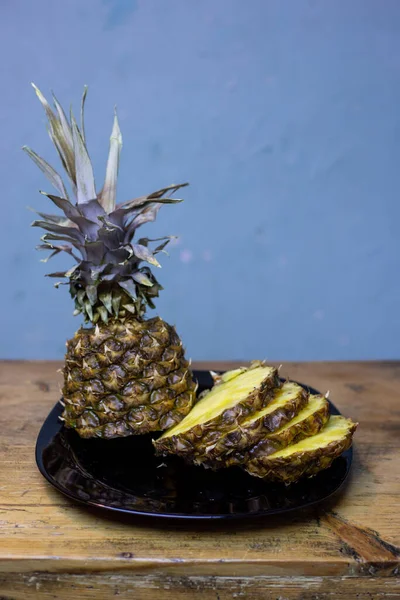 Piña en un plato. Corte y sobre una mesa de madera. —  Fotos de Stock