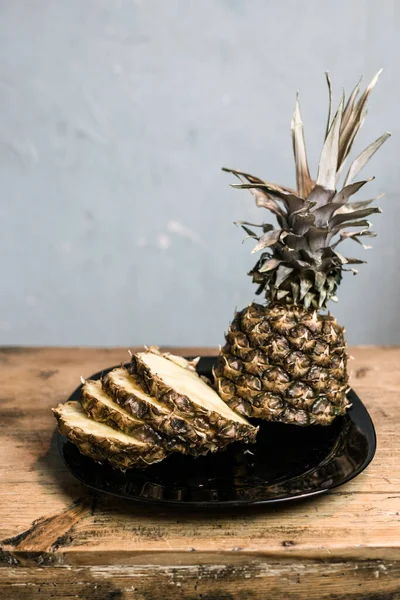 Pineapple on a plate. Cut and on a wooden table. — Stock Photo, Image